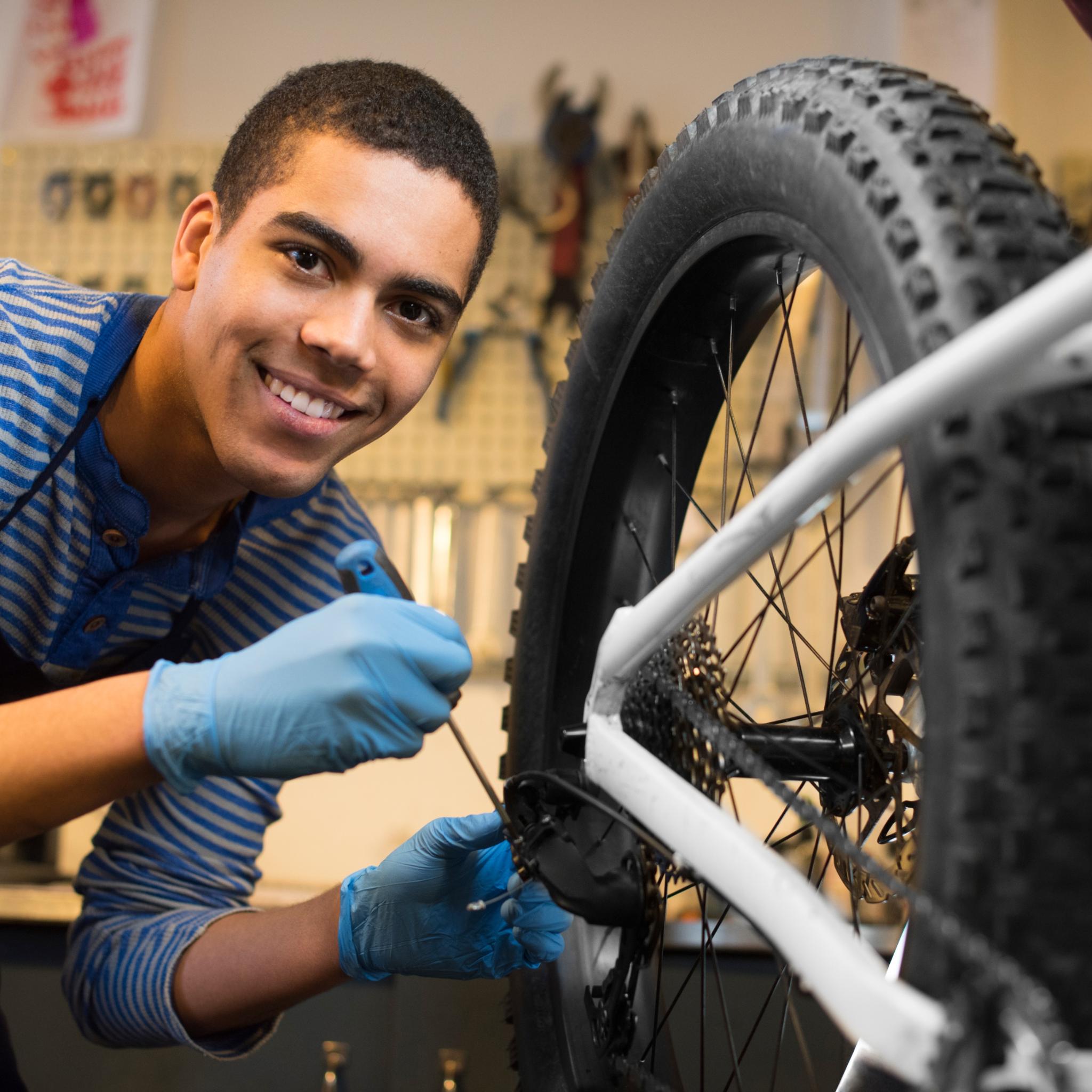 Junger Mechaniker in Fahrradwerkstatt